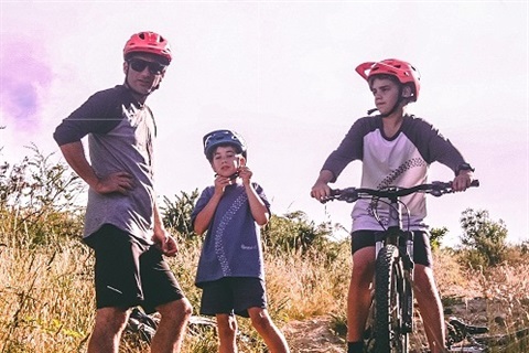 Father and children wearing bike helmets