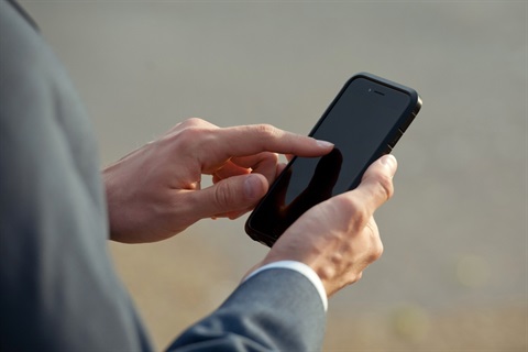 Man in suit tapping on phone