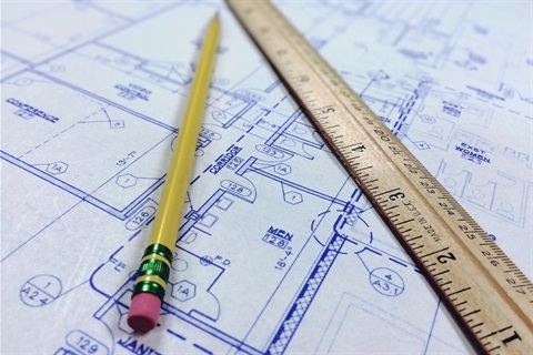 Pencil, ruler and blueprint of a house