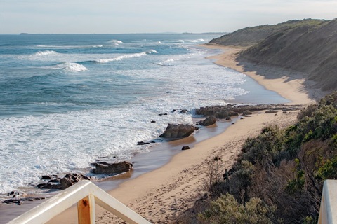 Looking out over a beach at the top of the stairs