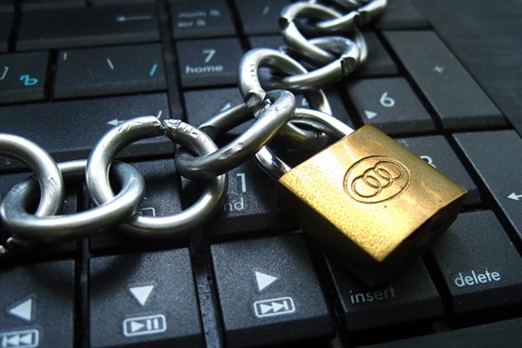 Padlock and chain resting on top of a laptop keyboard